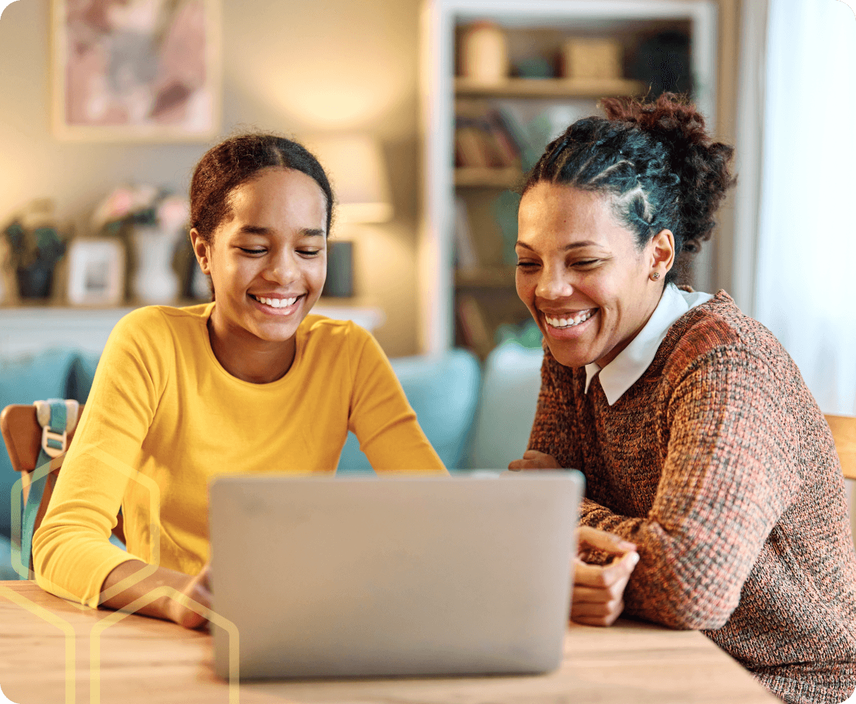 Teacher and young person working on a laptop together