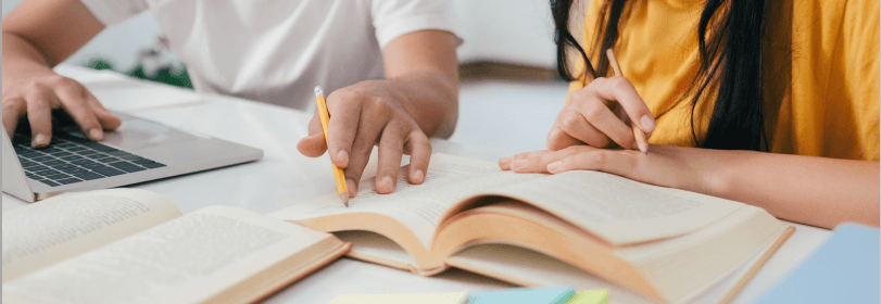 Image of young people working though a book