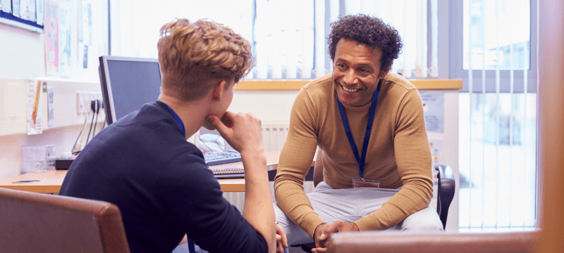 Image of a young person and teacher having a discussion