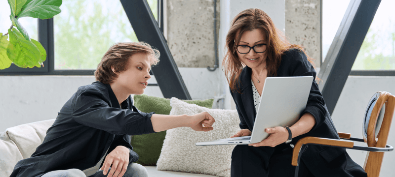 Image of a young person and teacher working on a laptop